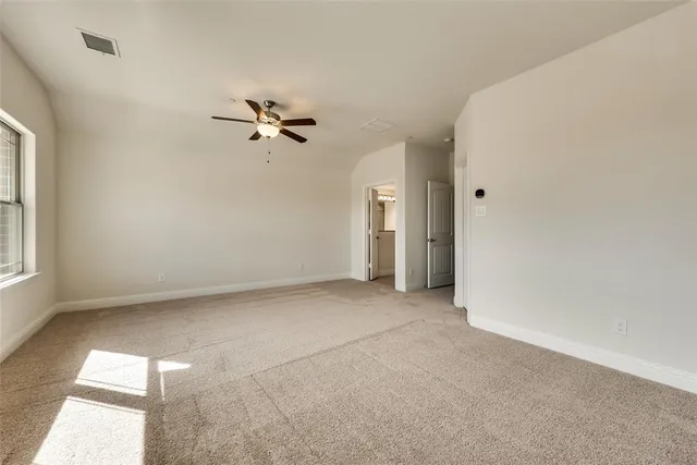 an empty room with fan and windows