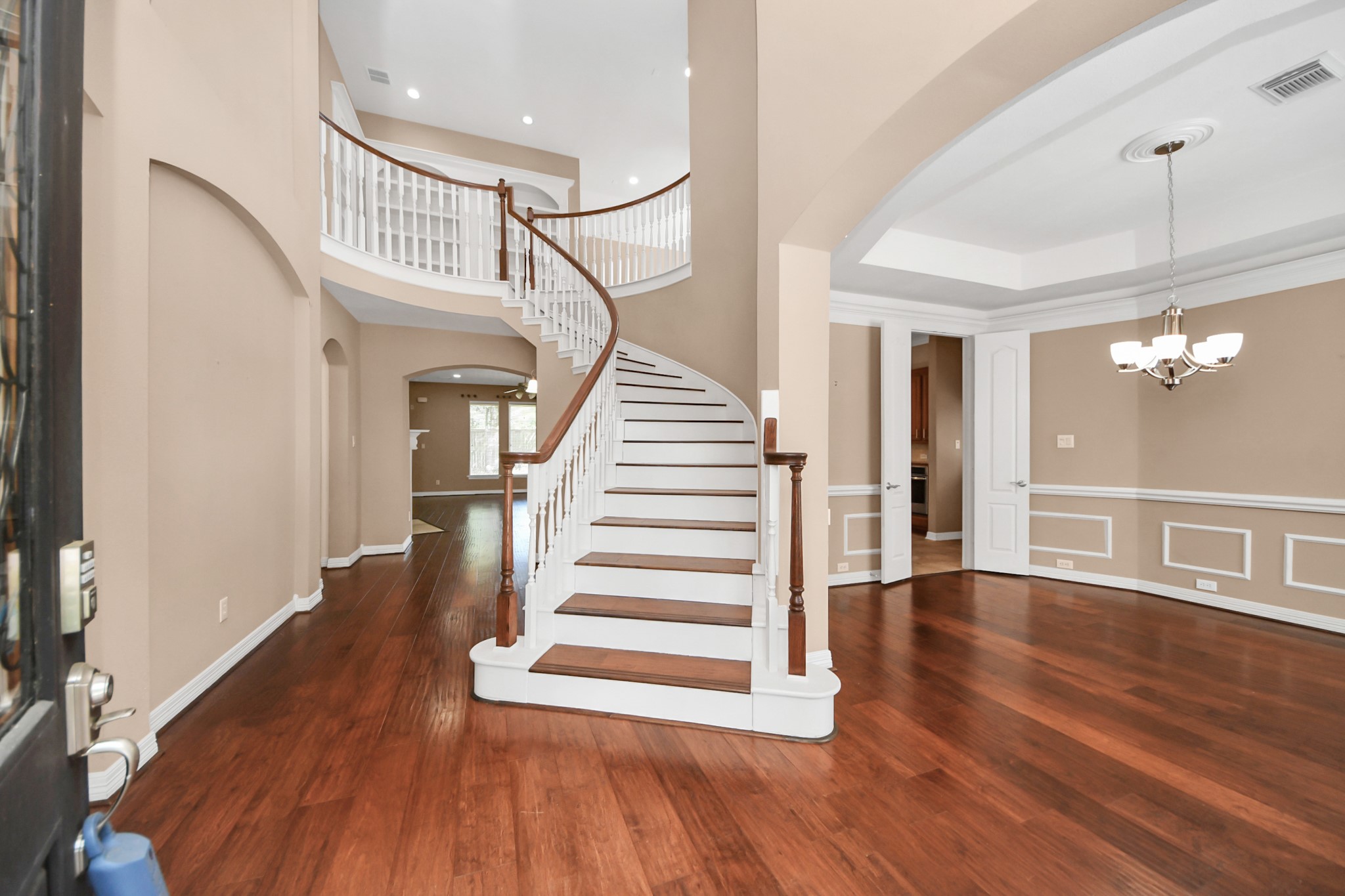 17618 Raven Canyon Lane Houston, TX 77095 - Photo 3 of 45 The grand entryway featuring a sweeping staircase and elegant wood flooring, creating a welcoming first impression.