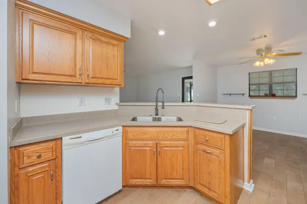 a kitchen with stainless steel appliances granite countertop a sink and dishwasher with white cabinets