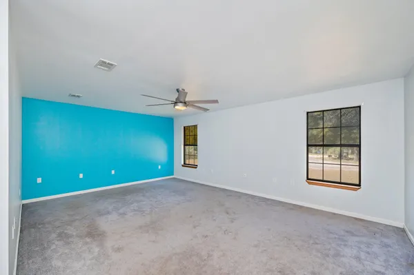 an empty room with windows and closet