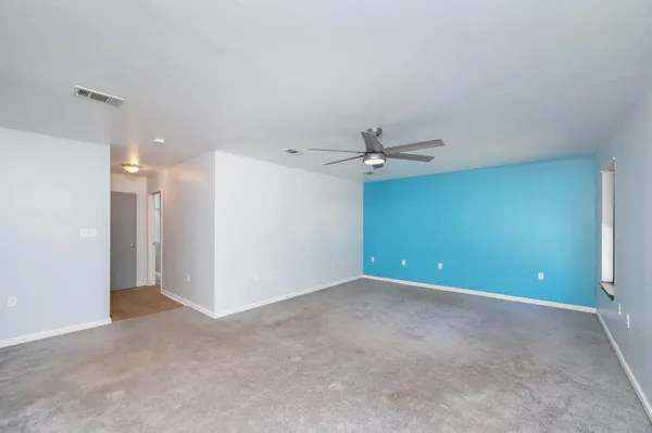 a view of an empty room with a ceiling fan