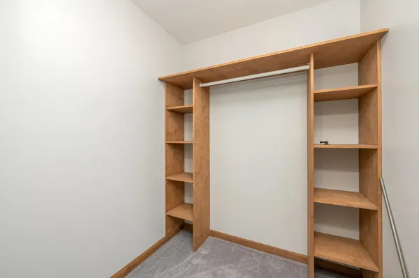 a view of walk in closet with empty racks