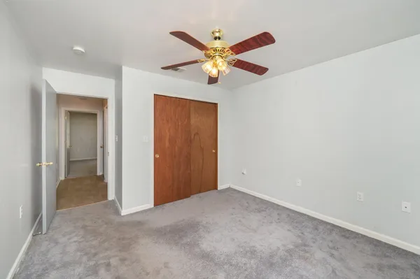 a view of an empty room with a ceiling fan
