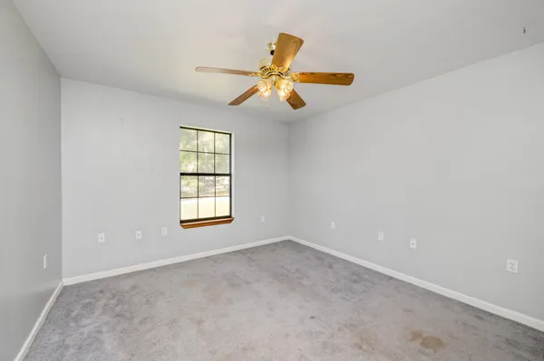an empty room with closet and fan