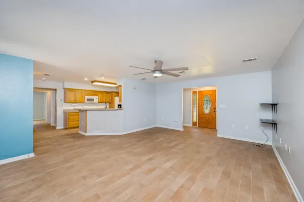 a view of a big room with wooden floor and a ceiling fan