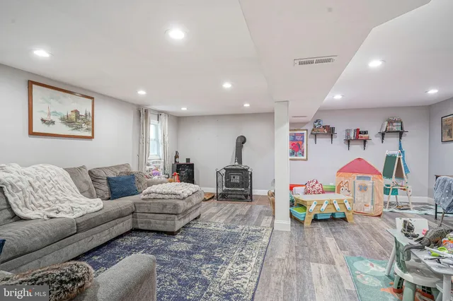 a living room with furniture a couch and dresser with wooden floor