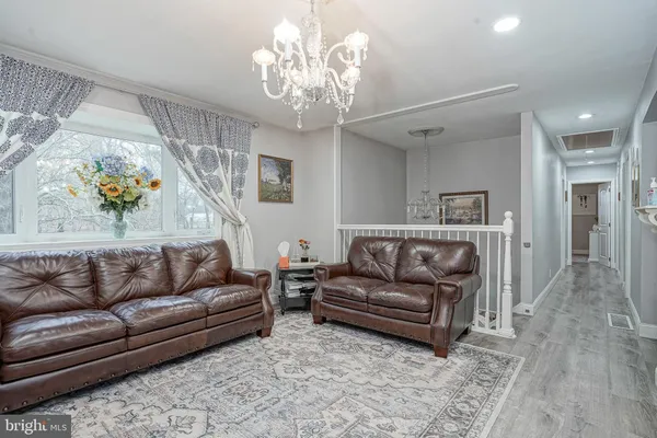 a living room with furniture and a chandelier