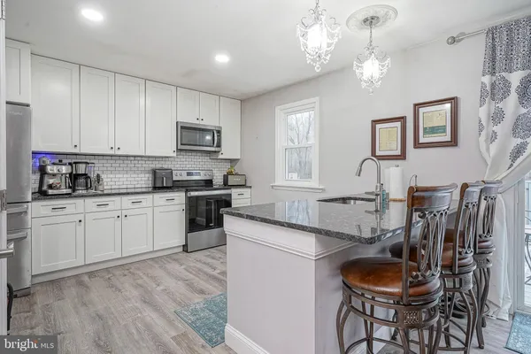 a kitchen with stainless steel appliances granite countertop a sink a stove a microwave a refrigerator and cabinets