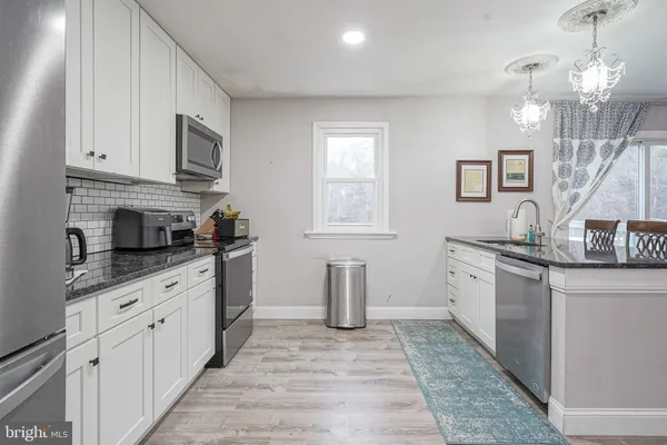 a kitchen with granite countertop a sink and stove top oven
