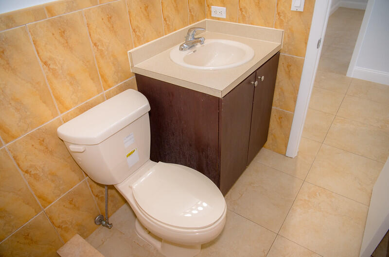 414 Coconut Drive Key Largo, FL 33037 - Photo 15 of 36 a white toilet sitting next to a bathroom sink