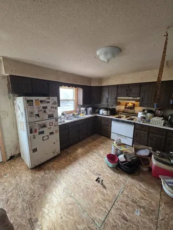 a kitchen with microwave a stove and cabinets