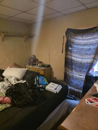 a bed sitting in a bedroom next to a window