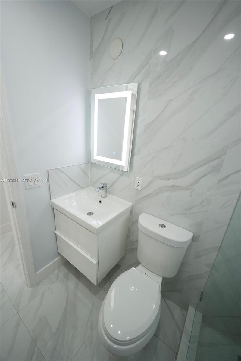 10381 Southwest 32nd Street Miami, FL 33165 - Photo 13 of 38 a white toilet sitting next to a bathroom sink
