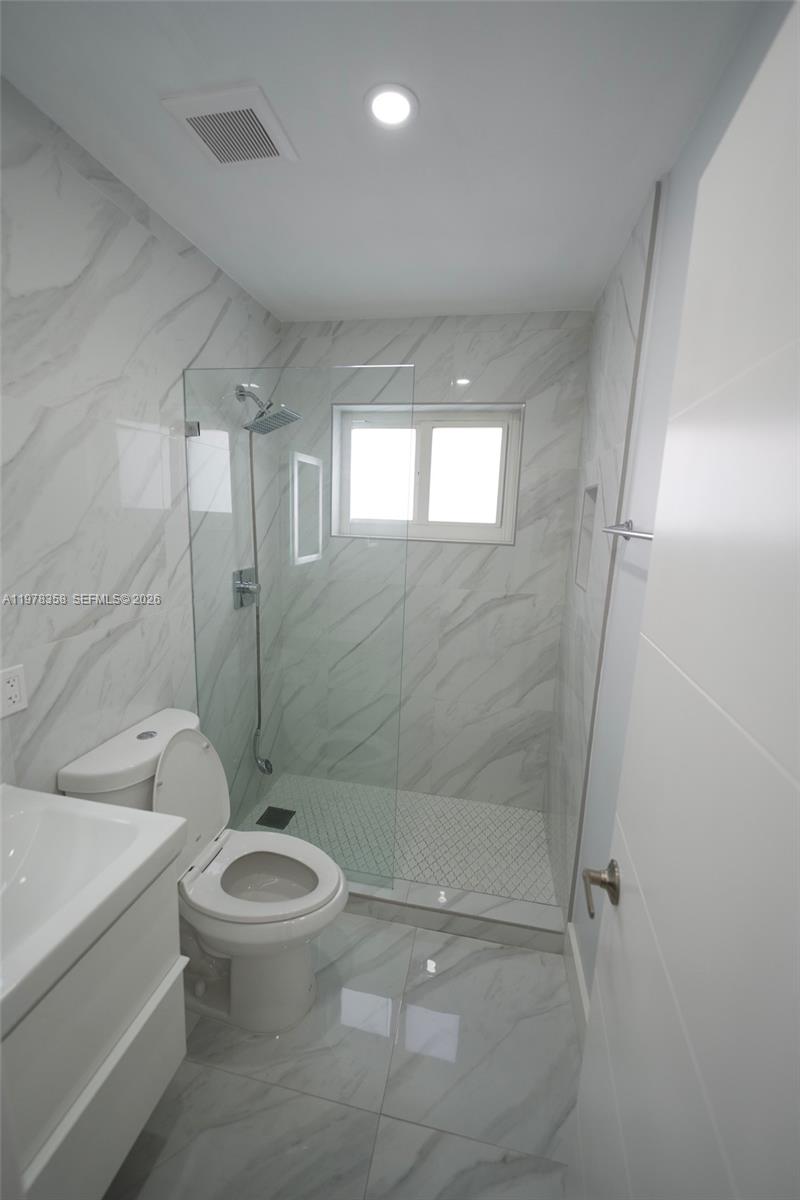 10381 Southwest 32nd Street Miami, FL 33165 - Photo 14 of 38 a bathroom with a toilet a sink and shower