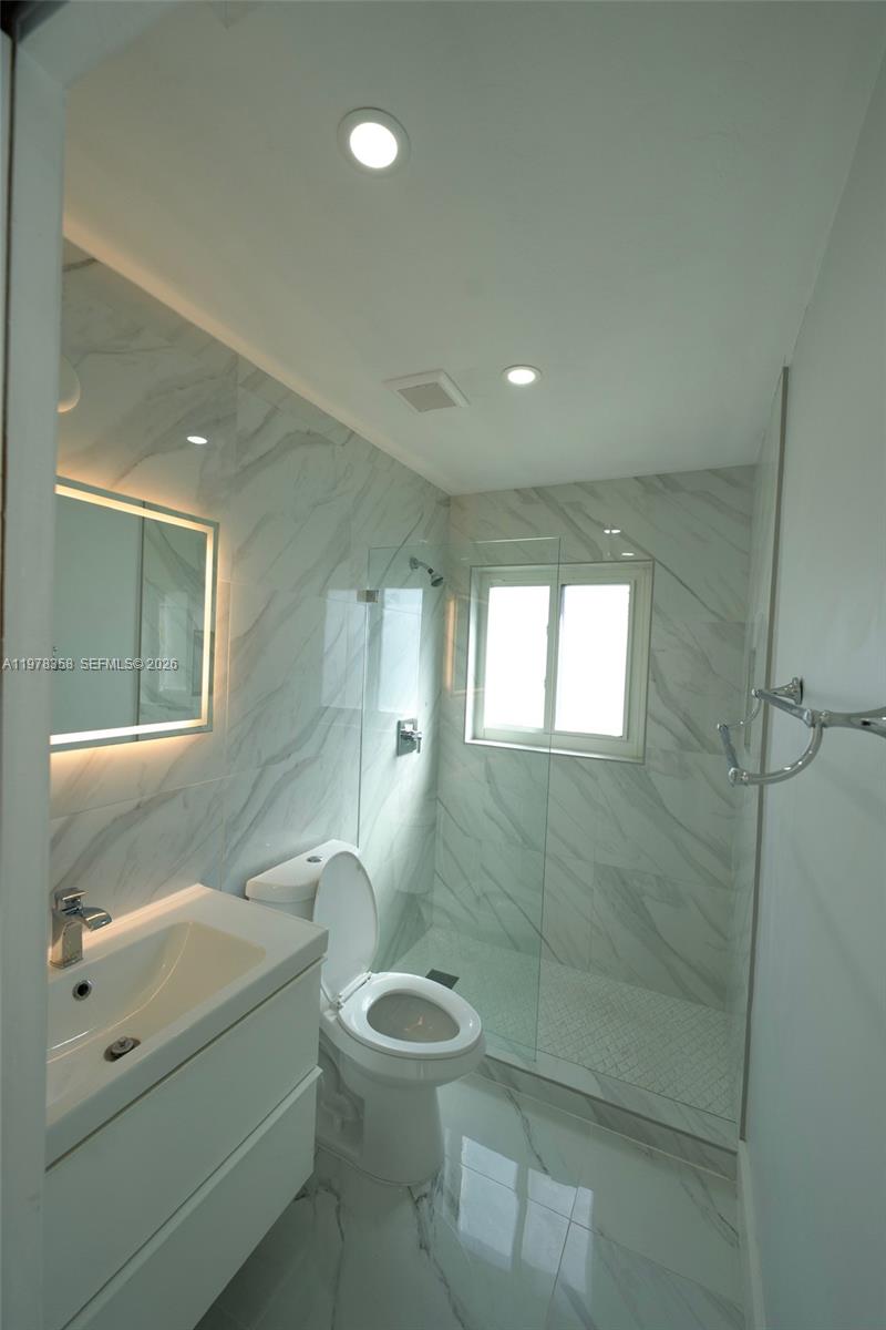 10381 Southwest 32nd Street Miami, FL 33165 - Photo 15 of 38 a bathroom with a toilet a sink and shower
