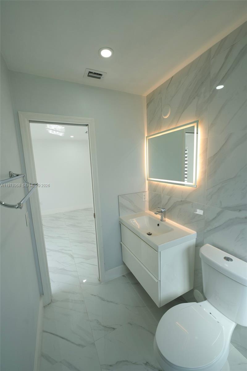 10381 Southwest 32nd Street Miami, FL 33165 - Photo 16 of 38 a bathroom with a sink mirror and toilet
