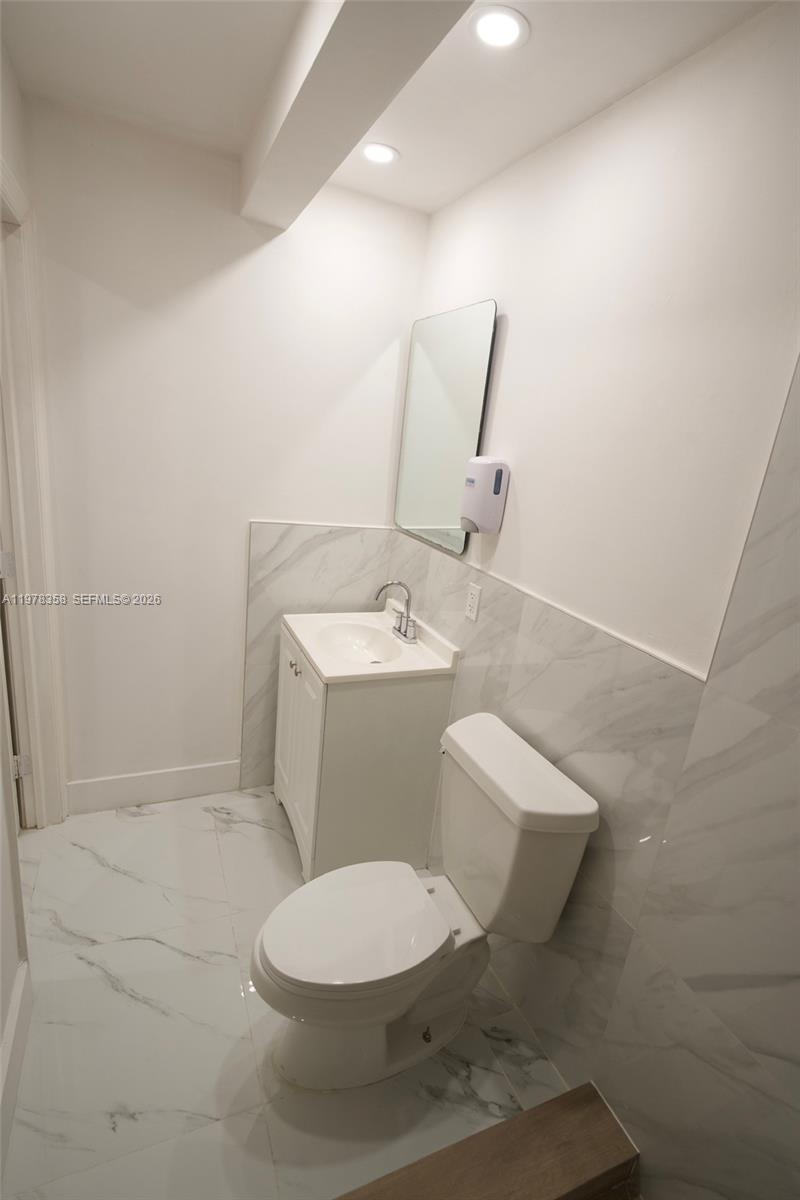 10381 Southwest 32nd Street Miami, FL 33165 - Photo 27 of 38 a white toilet sitting next to a bathroom sink and a mirror