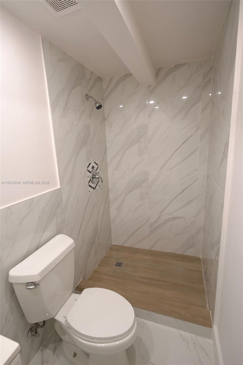 10381 Southwest 32nd Street Miami, FL 33165 - Photo 28 of 38 a white toilet sitting next to a bath tub and shower