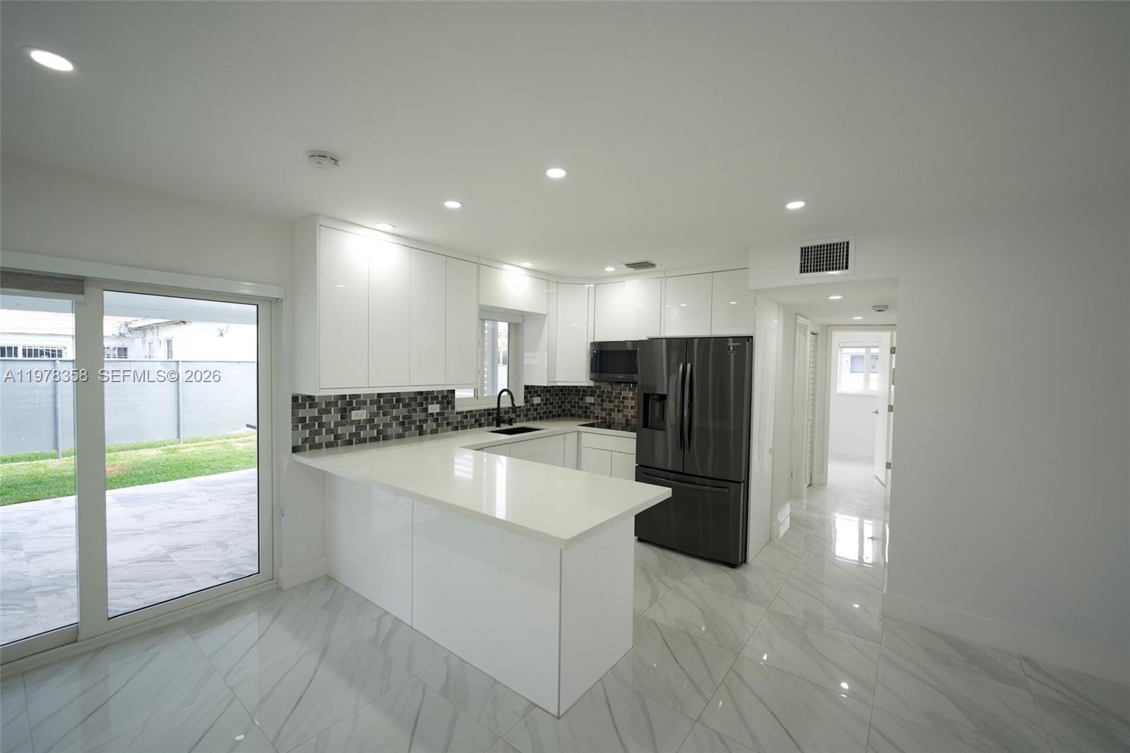 10381 Southwest 32nd Street Miami, FL 33165 - Photo 7 of 38 a large kitchen with a center island and stainless steel appliances