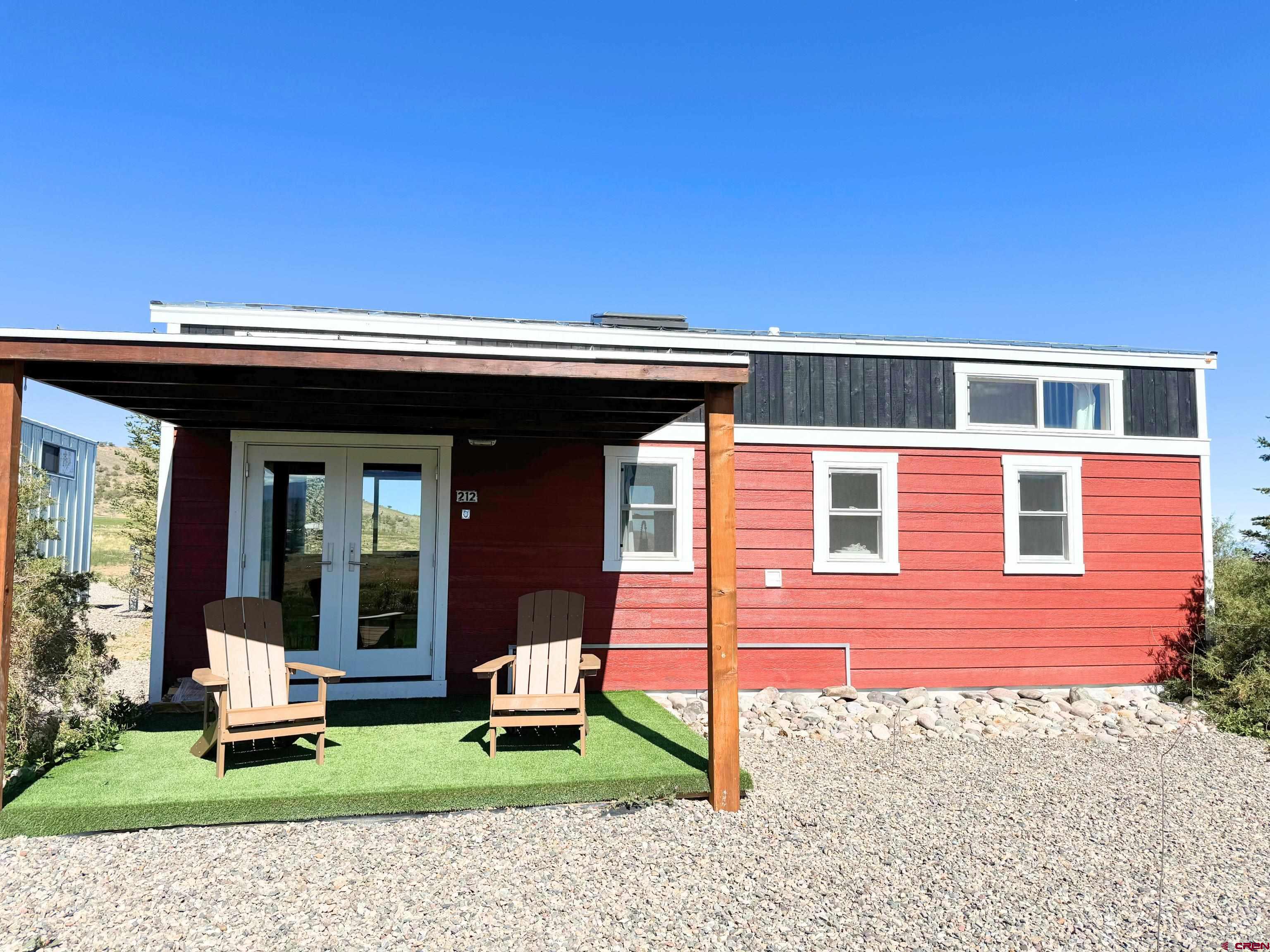 22130 6850 Road, Unit 210215 Montrose, CO 81403 - Photo 5 of 35 a view of a house with a yard and sitting area