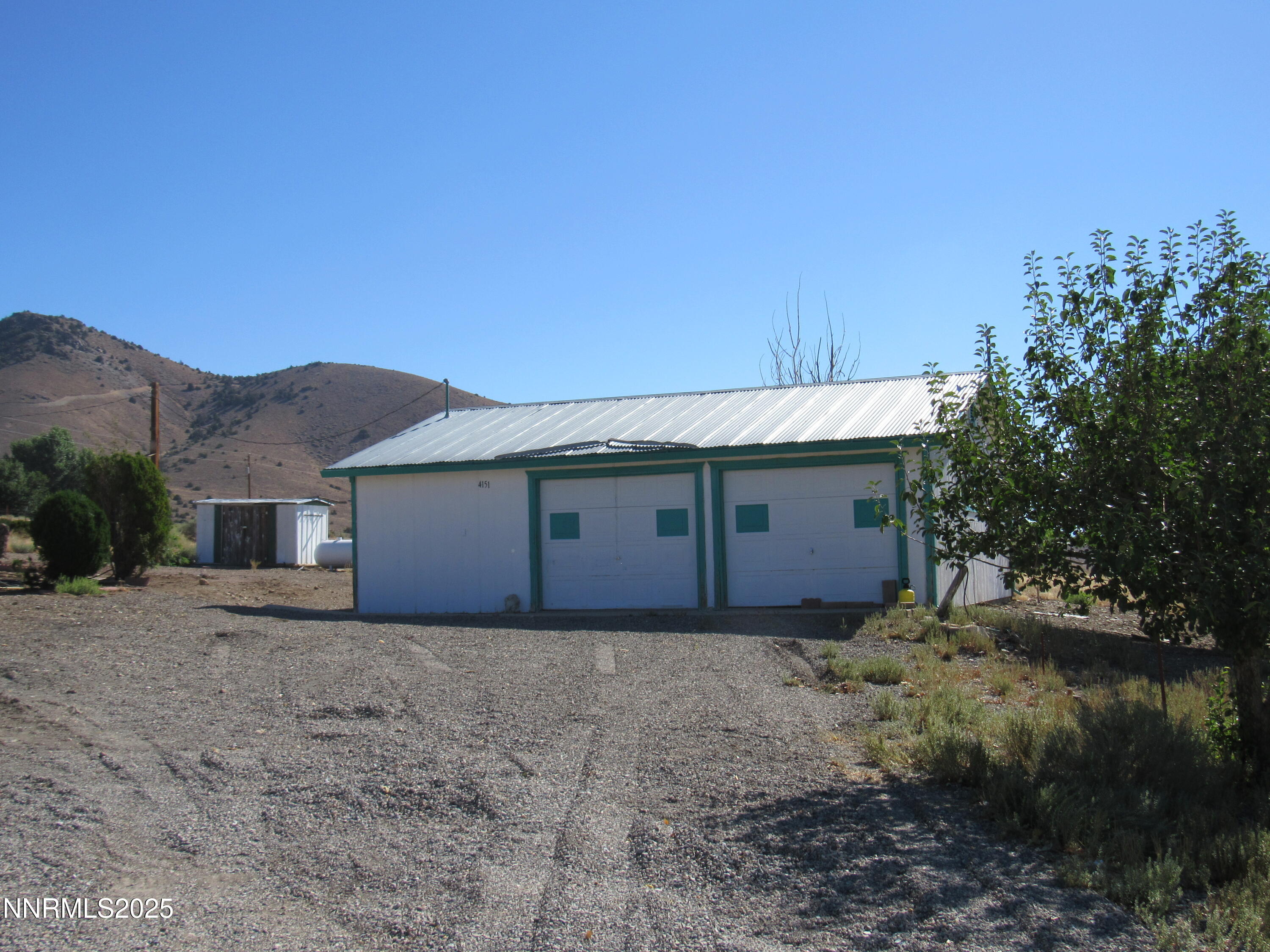 4151 Gray Hills Road Wellington, NV 89444 - Photo 4 of 25 a view of a house with a yard and a large tree