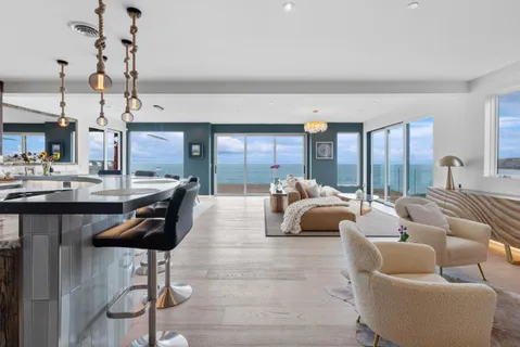 a living room with furniture and large windows