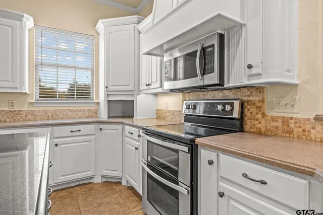 a kitchen with stainless steel appliances granite countertop a sink and cabinets