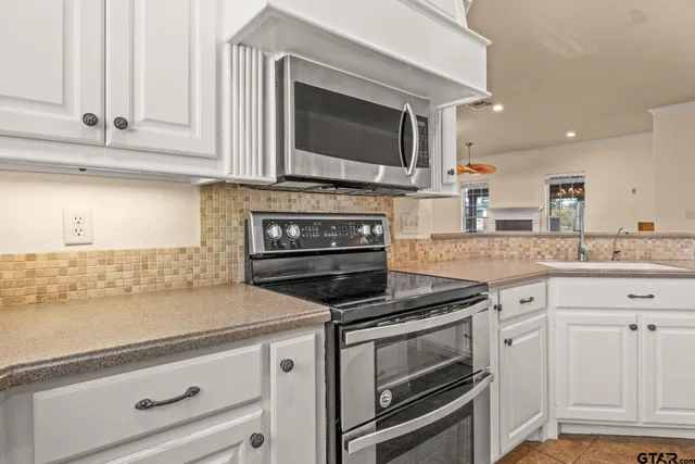 a kitchen with granite countertop a sink stainless steel appliances and cabinets