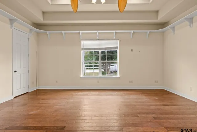 a view of an empty room with wooden floor