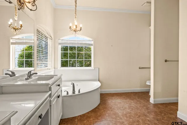 a spacious bathroom with a granite countertop sink mirror and a bathtub