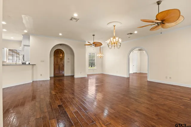 a view of a big room with wooden floor and a kitchen
