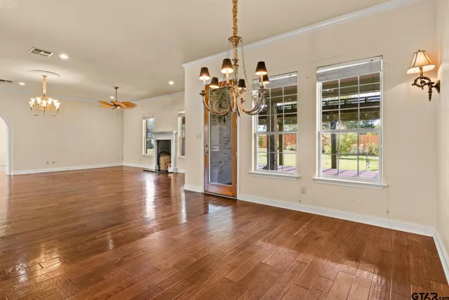 a kitchen with kitchen island a sink a stove a refrigerator and white cabinets with wooden floor