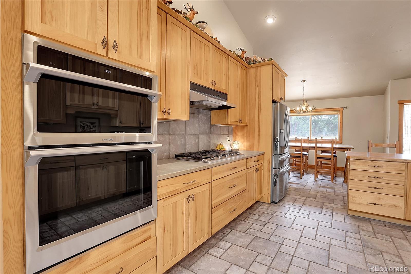 2063 Roland Drive Bailey, CO 80421 - Photo 16 of 49 a kitchen with granite countertop a stove top oven microwave and cabinets