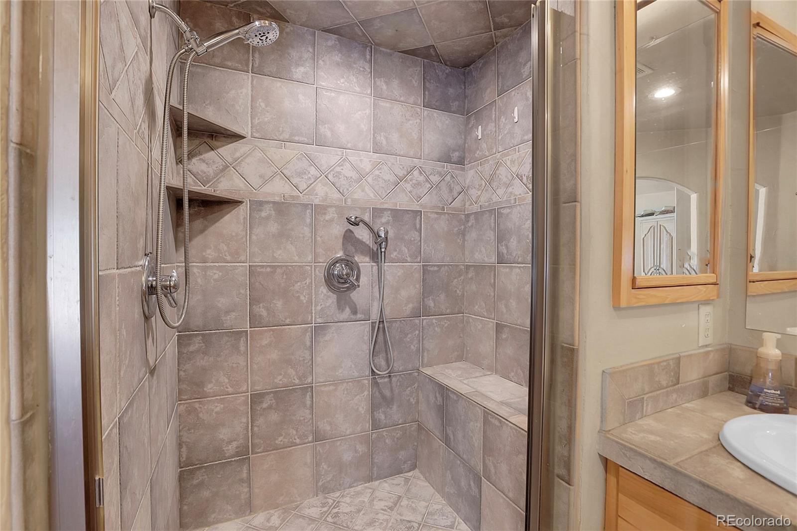2063 Roland Drive Bailey, CO 80421 - Photo 25 of 49 a bathroom with a granite countertop shower and a sink