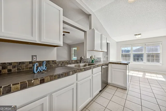 a kitchen with stainless steel appliances granite countertop a sink and cabinets