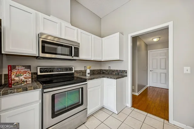 a kitchen with granite countertop cabinets stainless steel appliances and a counter space