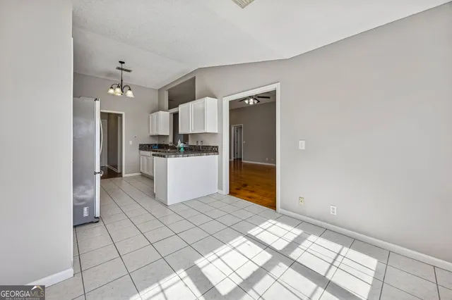 a kitchen with granite countertop a stove a sink and a refrigerator