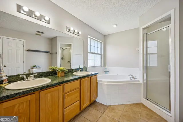 a spacious bathroom with a sink double vanity mirror and a bathtub