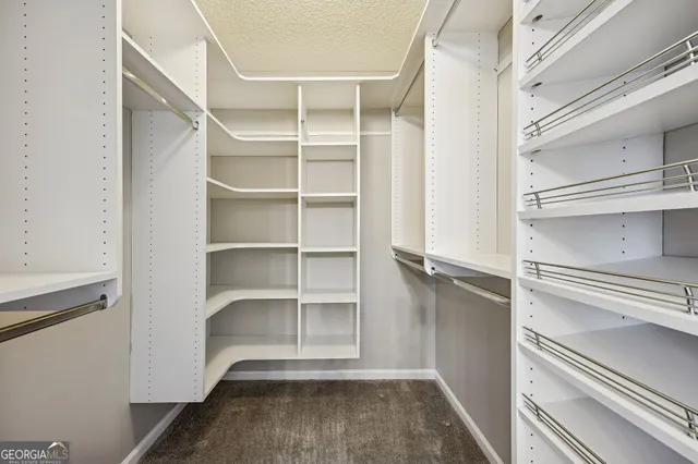 a view of walk in closet with empty racks