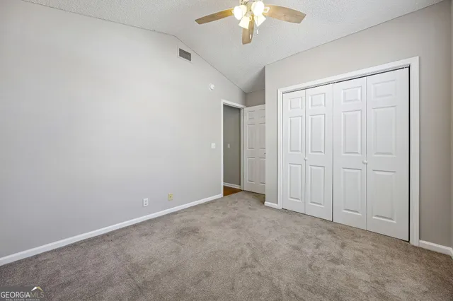 an empty room with a chandelier fan