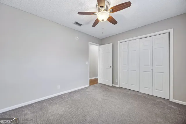 an empty room with chandelier fan