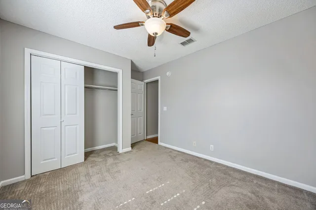an empty room with closet and windows