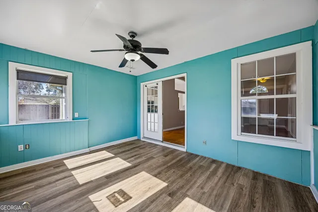 a view of empty room with window and wooden floor