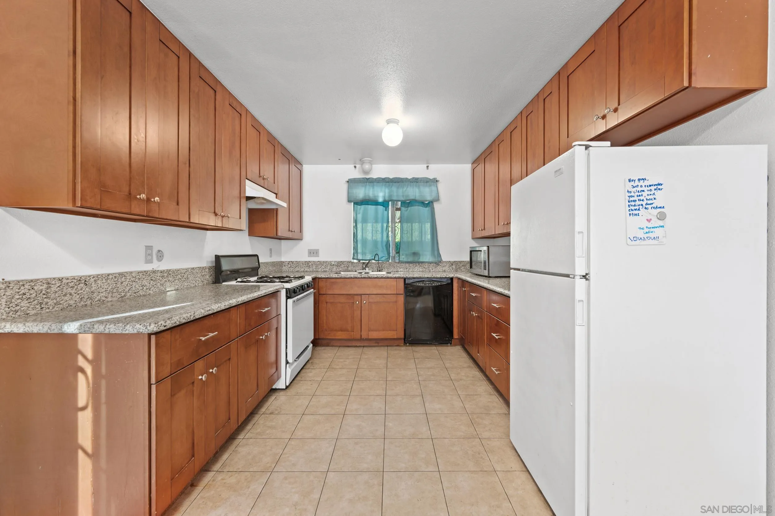 225 Deep Dell Road San Diego, CA 92114 - Photo 7 of 17 a kitchen with a sink a refrigerator and cabinets