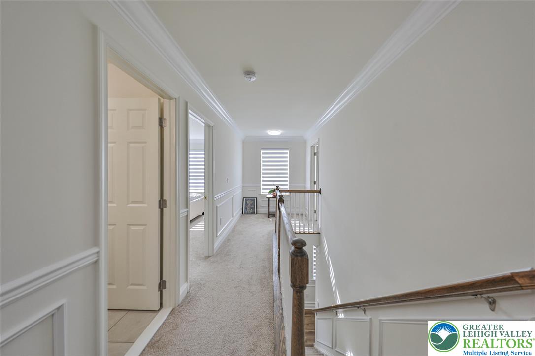 1105 Meco Road Easton, PA 18040 - Photo 71 of 100 Classic crown molding and wainscoting line this upper-level hallway leading past bright rooms.
