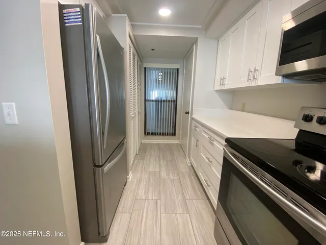 a kitchen with stainless steel appliances a refrigerator and a stove top oven