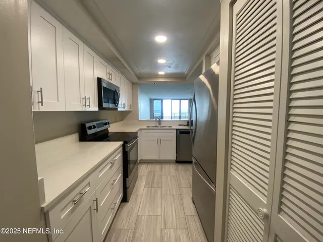 a kitchen with stainless steel appliances a refrigerator sink and cabinets