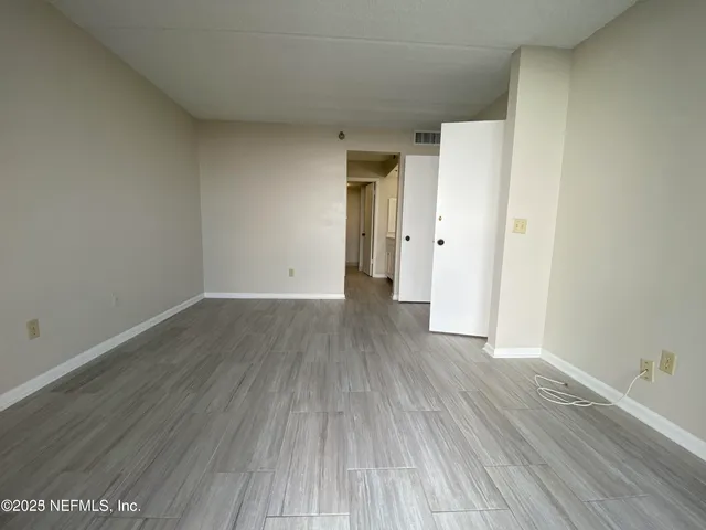 a view of a room with wooden floor and white doors