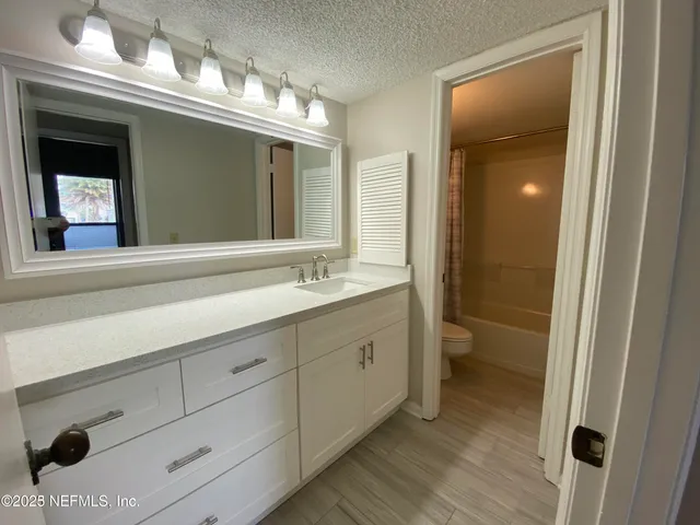 a bathroom with a double vanity sink mirror and toilet