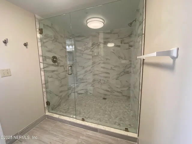 a bathroom with a glass shower door